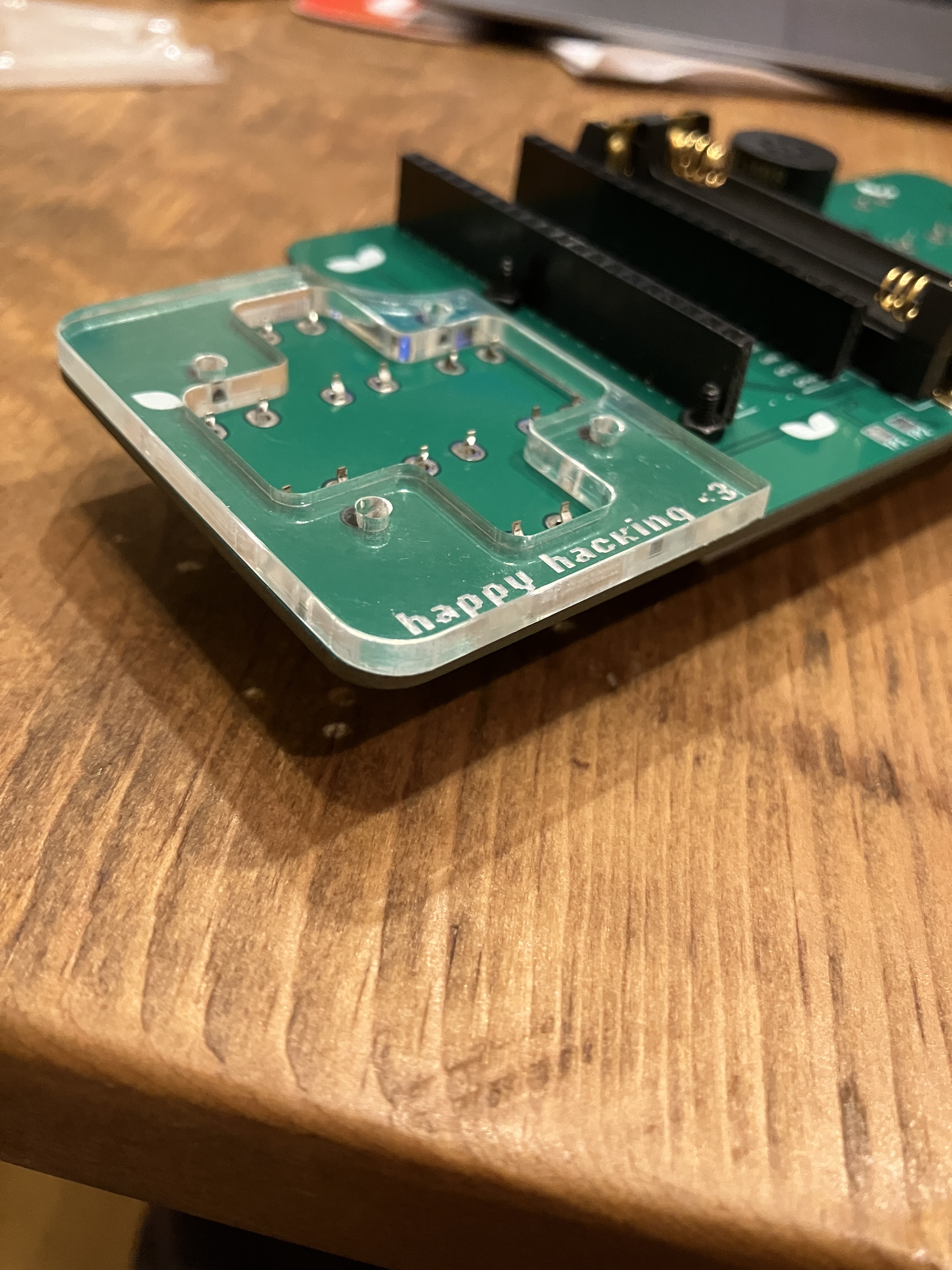 Foto de um pedaço de plástico com um recorte D-pad em um PCB